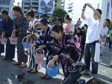 辛島公園周辺で打ち水をする参加者の方々